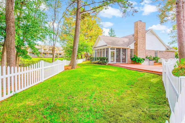 view of yard with a sunroom and a wooden deck