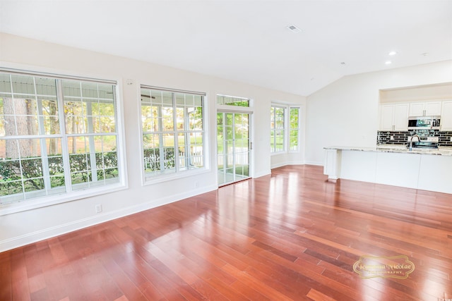 unfurnished living room with lofted ceiling and hardwood / wood-style flooring