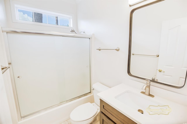 full bathroom with bath / shower combo with glass door, vanity, and toilet