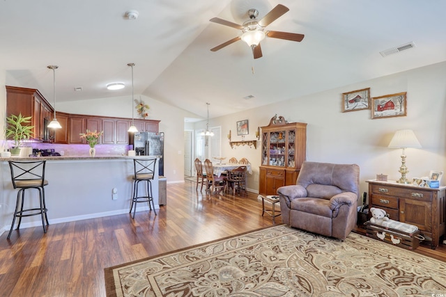 living room featuring hardwood / wood-style flooring, vaulted ceiling, and ceiling fan