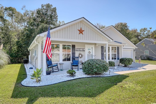 view of front of home featuring central AC, covered porch, a front yard, and a garage