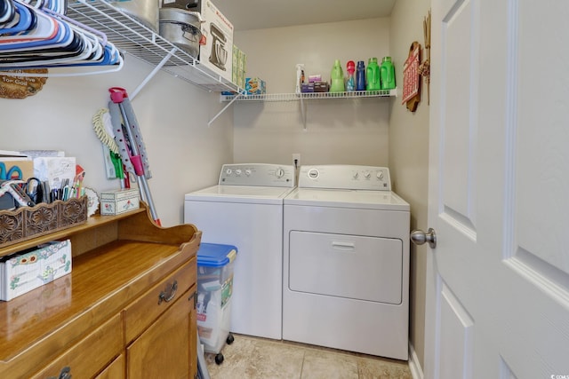 clothes washing area featuring light tile patterned floors and washing machine and dryer