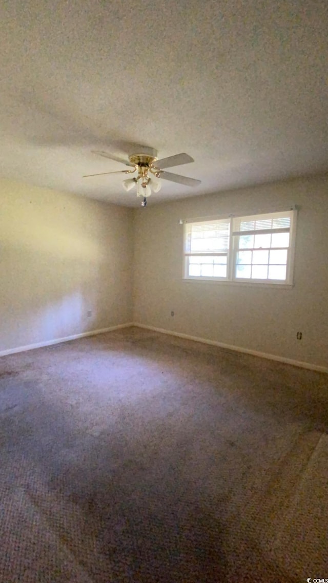 spare room with a wealth of natural light, a textured ceiling, and carpet floors