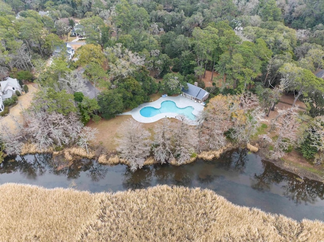 drone / aerial view with a wooded view and a water view