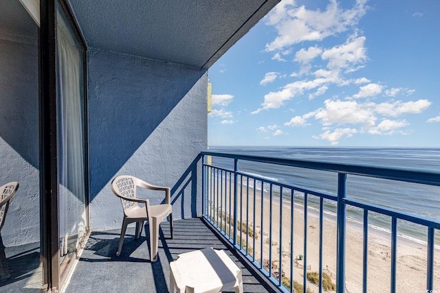 balcony featuring a beach view and a water view