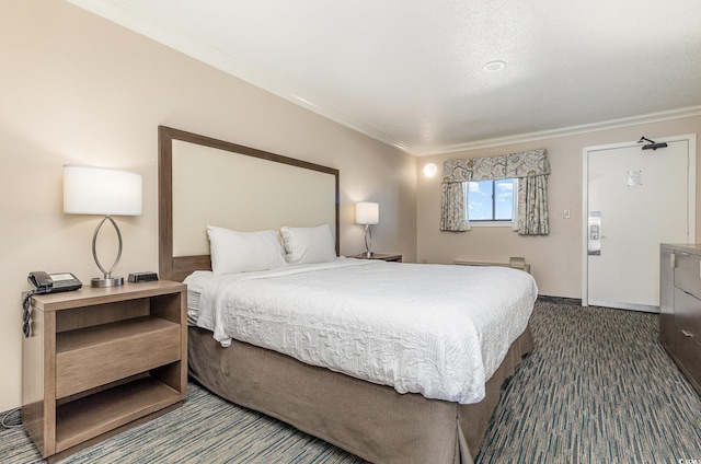 bedroom with crown molding and dark colored carpet