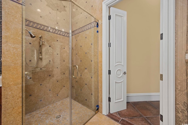 full bathroom featuring a shower stall and baseboards