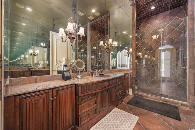 full bath featuring vanity, tile patterned floors, a notable chandelier, and a stall shower