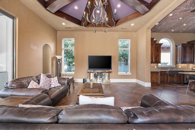 living room featuring dark tile patterned flooring, arched walkways, and a wealth of natural light