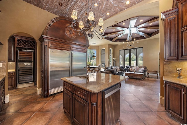 kitchen with decorative light fixtures, light stone countertops, appliances with stainless steel finishes, and open floor plan