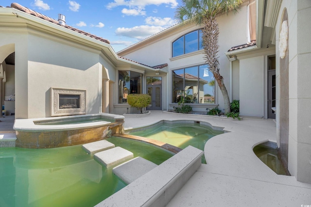 view of pool featuring a patio and a pool with connected hot tub