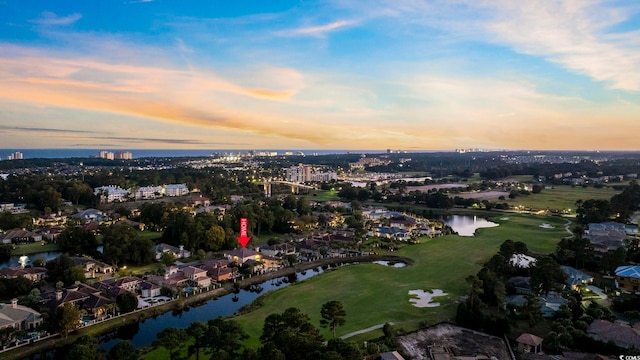 aerial view at dusk featuring a water view