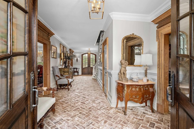 hall featuring an inviting chandelier and crown molding