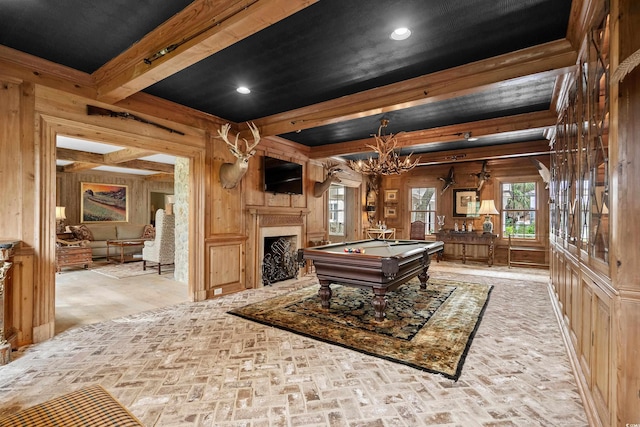 rec room featuring beam ceiling, wooden walls, pool table, and a chandelier