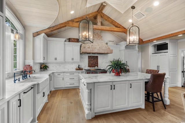 kitchen with wood ceiling, decorative light fixtures, vaulted ceiling with beams, and a kitchen island