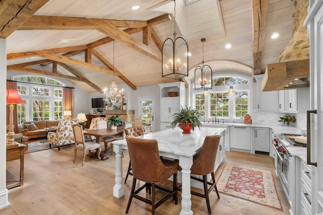 dining room with wood ceiling, sink, lofted ceiling with beams, a notable chandelier, and light wood-type flooring