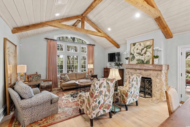 living room with lofted ceiling with beams, wooden ceiling, light hardwood / wood-style flooring, and a fireplace