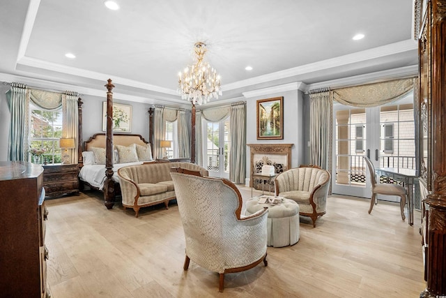 bedroom featuring a raised ceiling, access to outside, light hardwood / wood-style flooring, and a chandelier