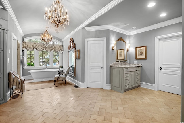 bathroom with vanity, ornamental molding, a chandelier, and a bathtub