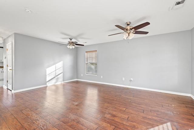 empty room with ceiling fan and dark hardwood / wood-style flooring