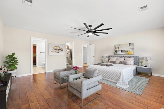 bedroom with a closet, a walk in closet, hardwood / wood-style floors, ensuite bathroom, and ceiling fan