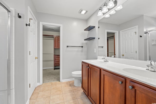 bathroom featuring vanity, toilet, walk in shower, and tile patterned flooring