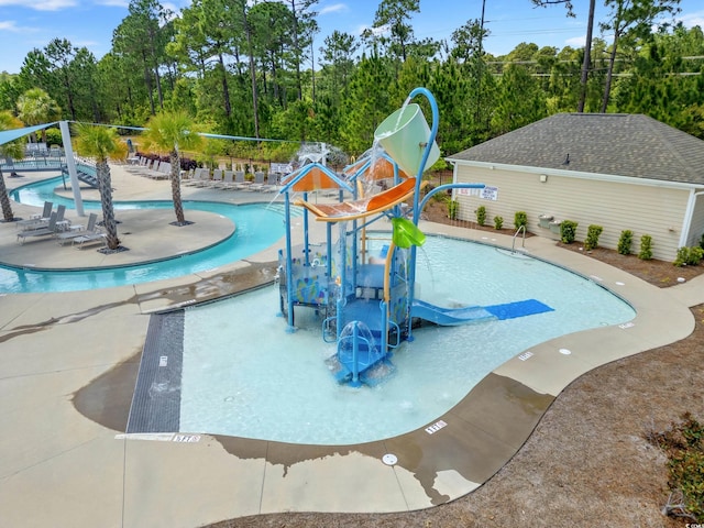 view of pool with a water slide and a patio