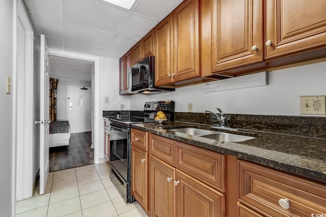 1501 S Ocean Blvd Unit 240, Myrtle Beach, SC 29577 - kitchen featuring black appliances, brown cabinets, dark stone counters, and light tile patterned floors