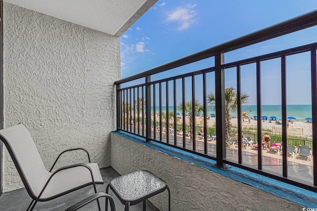 balcony featuring a water view and a beach view