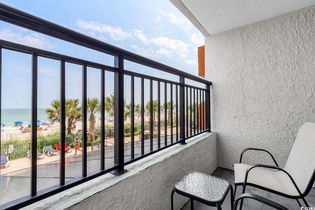 balcony with a water view and a beach view