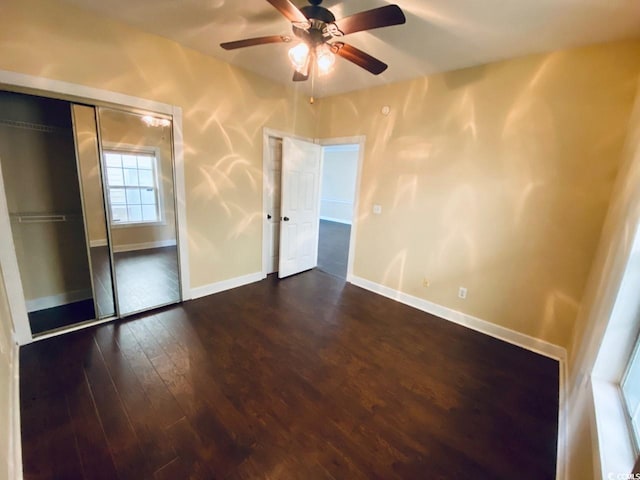 unfurnished bedroom featuring a closet, ceiling fan, and dark hardwood / wood-style flooring