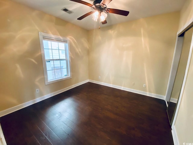 empty room featuring ceiling fan and dark hardwood / wood-style flooring