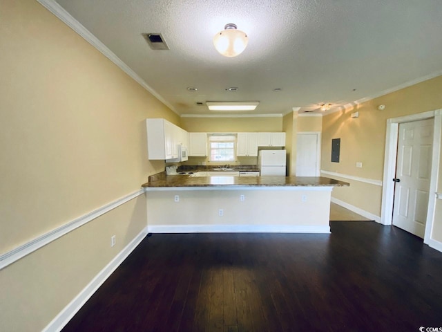 kitchen featuring kitchen peninsula, dark hardwood / wood-style flooring, white appliances, and white cabinets