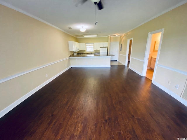 unfurnished living room with ceiling fan, crown molding, and dark wood-type flooring