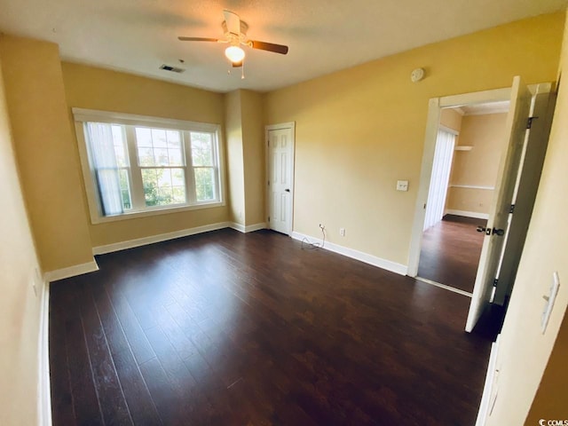 empty room featuring dark hardwood / wood-style flooring and ceiling fan