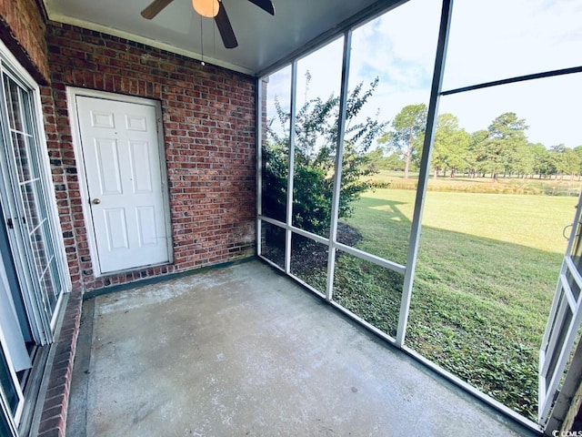 unfurnished sunroom with ceiling fan