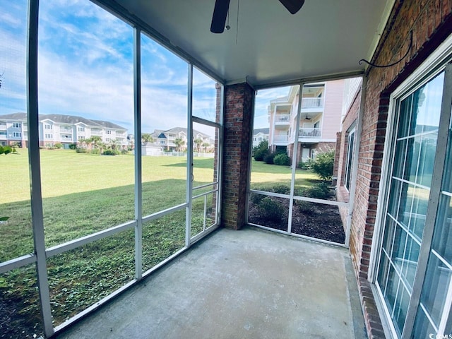 unfurnished sunroom featuring ceiling fan