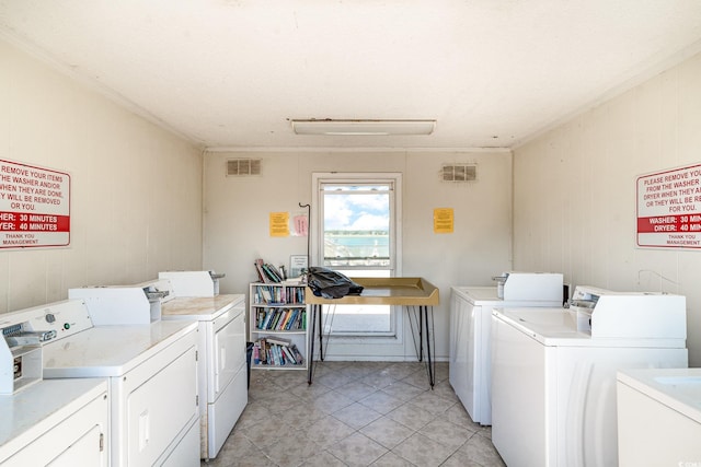 1582 S Waccamaw Dr Unit 60, Garden City Beach, SC 29576 - shared laundry area featuring light tile patterned flooring, wood walls, visible vents, and washing machine and dryer