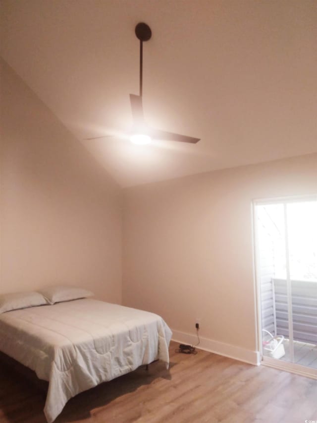 bedroom featuring access to exterior, vaulted ceiling, ceiling fan, and hardwood / wood-style floors