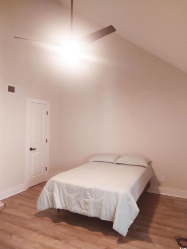 bedroom featuring wood-type flooring and vaulted ceiling