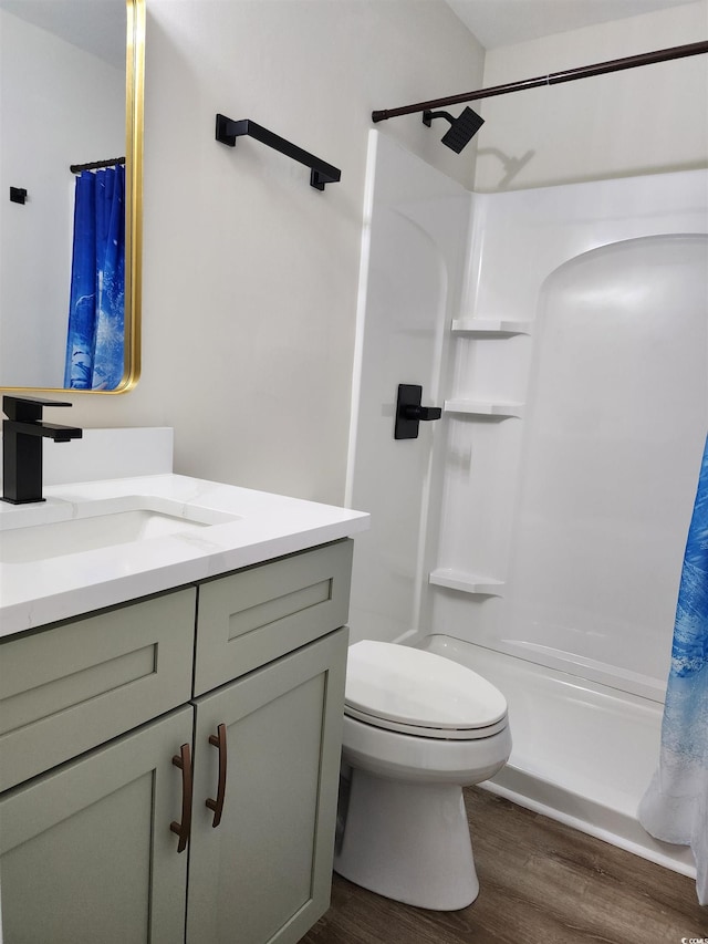 full bathroom with shower / tub combo with curtain, hardwood / wood-style flooring, vanity, and toilet