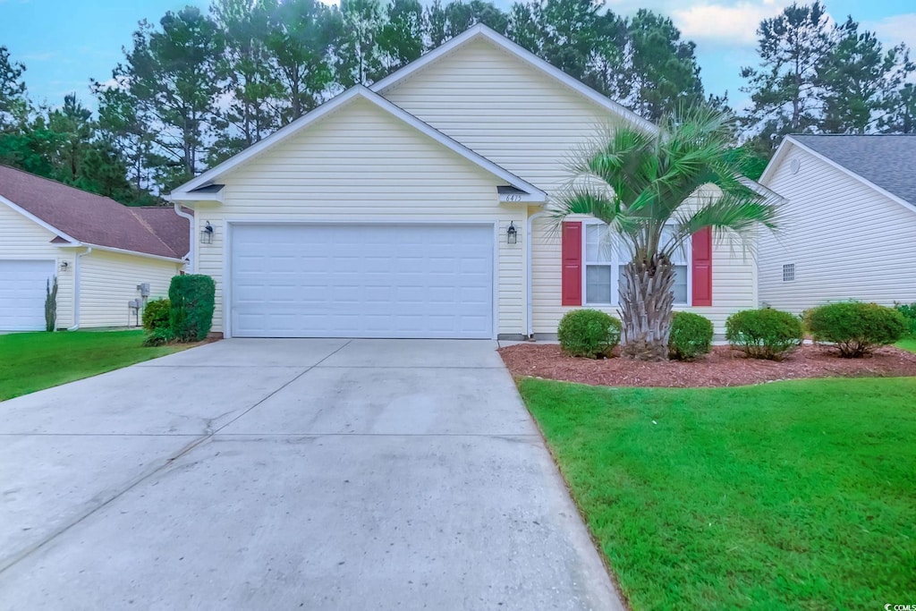 single story home featuring a garage and a front lawn