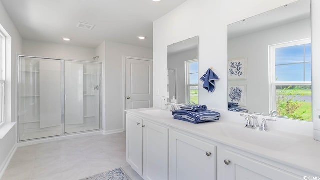 bathroom featuring tile patterned flooring, vanity, and a shower with door