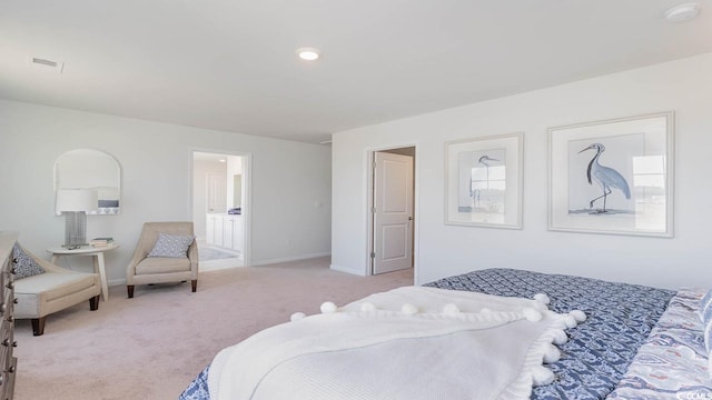 bedroom with light carpet and connected bathroom