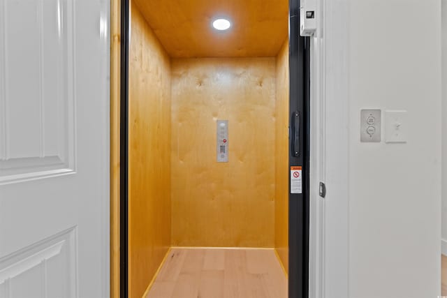 room details with hardwood / wood-style floors and elevator