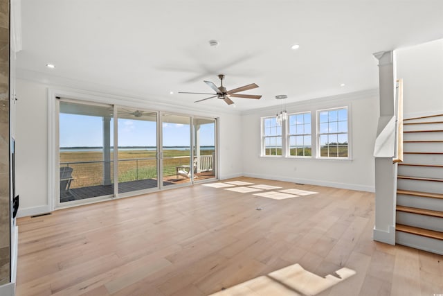 unfurnished living room featuring ceiling fan with notable chandelier, ornamental molding, and light hardwood / wood-style flooring