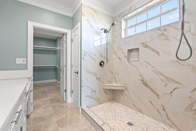 bathroom with a tile shower, ornamental molding, and vanity