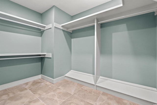 walk in closet with light tile patterned floors