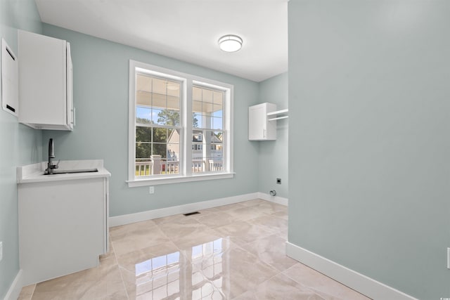 clothes washing area with cabinets, sink, and electric dryer hookup