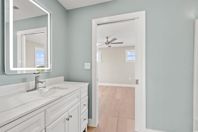 bathroom with hardwood / wood-style floors, vanity, and ceiling fan